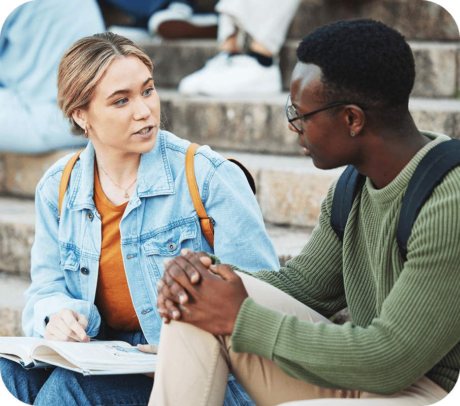 Deux jeunes assis sur des marches en train de discuter.