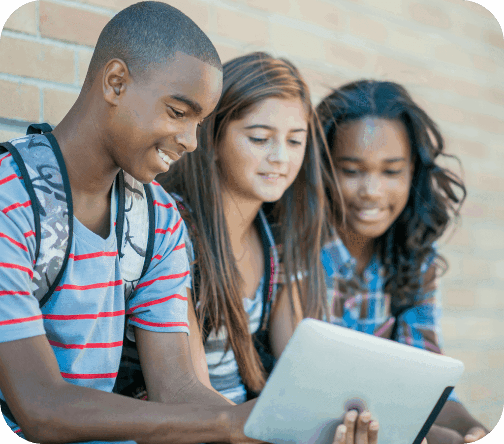 Trois jeunes assis ensemble en train de regarder une tablette.