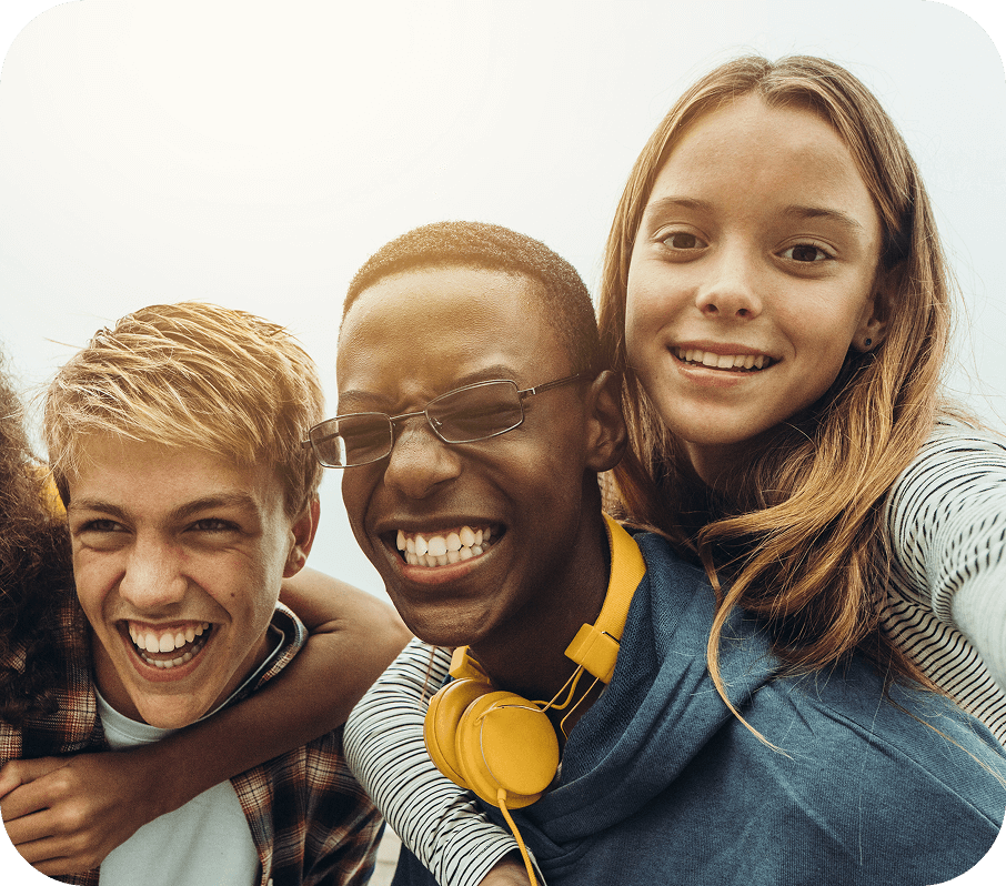 Un groupe de jeunes qui posent ensemble pour un égoportrait en souriant.